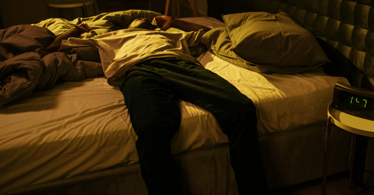 A man laying on a bed dealing with sedative addiction